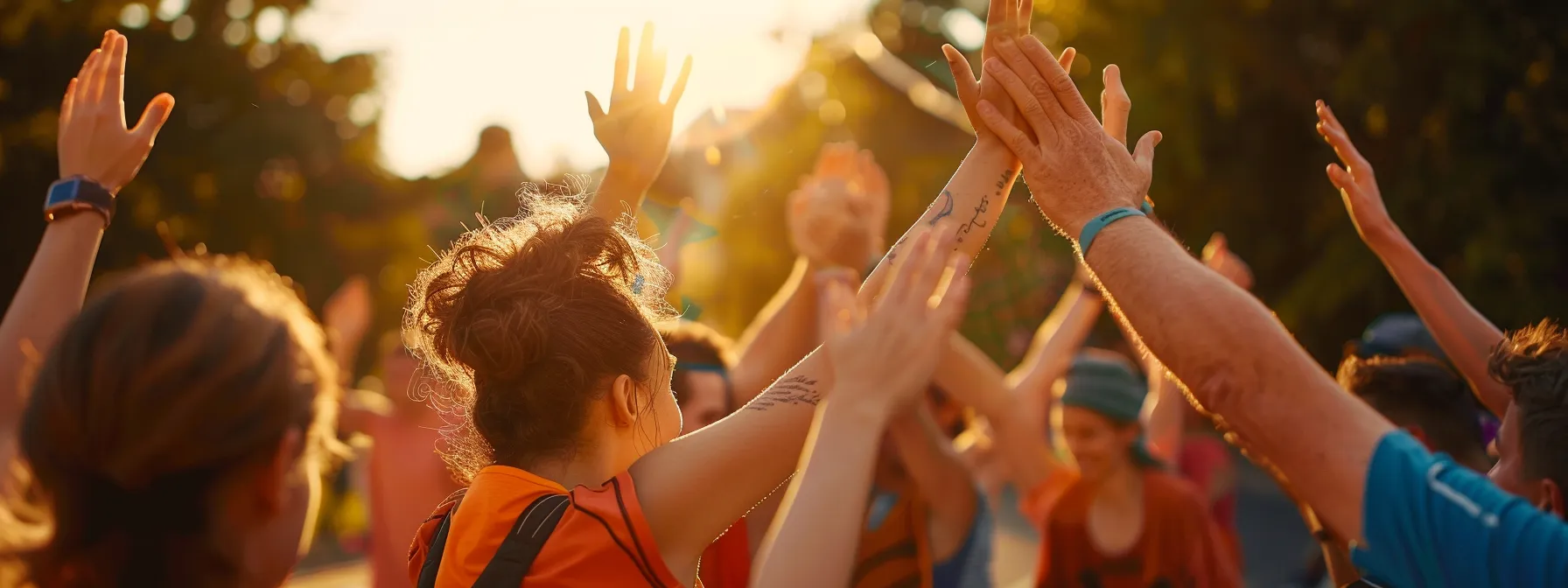 a diverse group of people high-fiving each other at the finish line of a race.